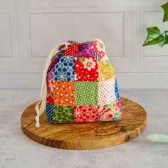 a colorful patchwork bag sitting on top of a wooden stand