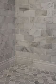 an instagramted photo of a bathroom with white marble tile on the shower wall