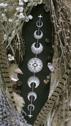 an arrangement of different types of flowers and plants on a black surface with white designs