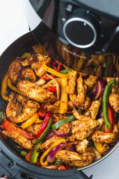 chicken fajita with peppers and onions is being cooked in an air fryer