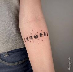 a woman's arm with phases of the moon tattoo on it