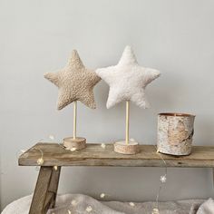 three star shaped candles are sitting on a wooden table