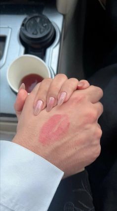 a person holding the hand of another person in a car with their arm wrapped around each other