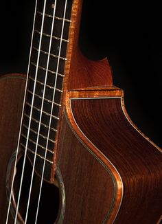 a close up of an acoustic guitar on a black background with the strings still attached