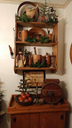 a wooden shelf filled with pots, pans and other items on top of it