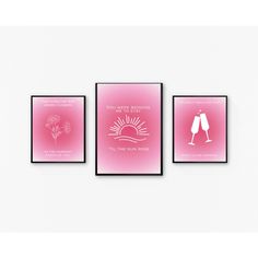 three framed posters with pink hues and white lettering on the wall above them are two champagne flutes