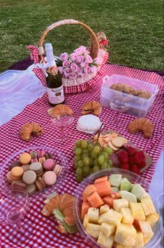 a picnic table with food and wine on it