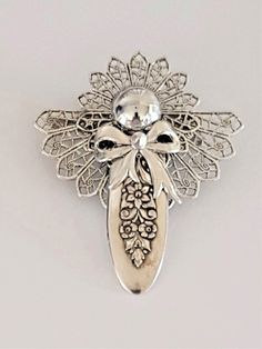 a silver brooch with an ornate design on it