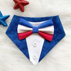 a red, white and blue bow tie on a dog's collar next to starfish