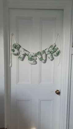 a white door with a green and white garland hanging from it's front door