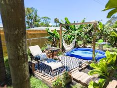 a backyard with a hammock, patio furniture and an inflatable pool