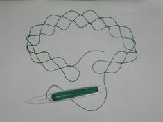 a drawing of a green object on top of a piece of paper next to a pair of scissors