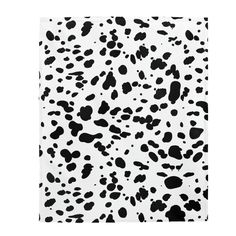 a black and white cow print towel on a white background, with spots all over it