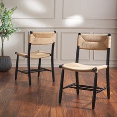 two chairs sitting next to each other on top of a hard wood floor in front of a white wall