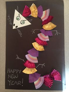 a handmade new year's card with colorful paper fan decorations on it, and the words happy new year written below