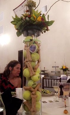 a tall vase filled with tennis balls on top of a table