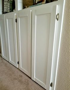 there is a white cabinet with three doors