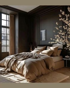 a large bed sitting in a bedroom next to a window with flowers on the wall