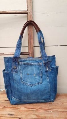 a blue jean purse sitting on top of a wooden table next to a ladder case