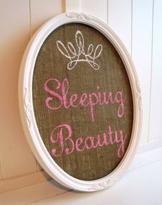 a sign that says sleeping beauty hanging on the side of a white wall next to a door