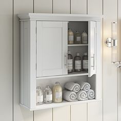 a bathroom cabinet with towels and soaps on it