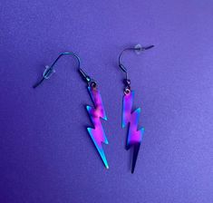 two pairs of lightning earrings on purple background