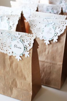 some brown paper bags with white doily on them