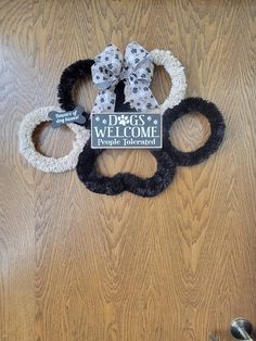 the dog's welcome door hanger is decorated with black and white hair accessories