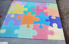 a colorful piece of puzzle painted on the sidewalk