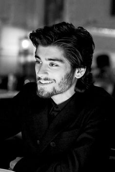 a man sitting at a table smiling for the camera