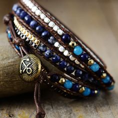 Introducing the Ethnic Blue Chic Wrap Bracelet, a stunning accessory that brings beauty and harmony to your daily life. Crafted with high-quality gemstones, this bracelet exudes a sense of elegance and sophistication, making it a perfect complement to any outfit. Not only does it enhance your appearance, but it also promotes balance and positive energy flow throughout your body. *Material: Jasper, Lapis Lazuli, Jade, Wax rope, Metal *Making Technics: Handmade Sewed *Size: 32.5 inches, 3 closures Bohemian Sapphire Round Bead Jewelry, Bohemian Sapphire Gemstone Beads Jewelry, Bohemian Sapphire Beaded Jewelry, Elegant Blue Hand-strung Crystal Bracelet, Adjustable Lapis Lazuli Beaded Bracelets Bohemian Style, Blue Bohemian Beaded Bracelets For Meditation, Bohemian Blue Beaded Bracelets For Meditation, Adjustable Lapis Lazuli Beaded Bracelets With Gemstone, Hand-strung Sapphire Beaded Bracelets