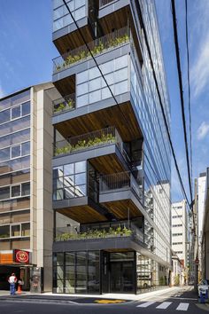 a tall building with many balconies and plants on it's balconys