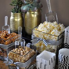 an assortment of snacks are displayed in glass containers on a table with succulents