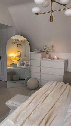 a bedroom with a bed, dresser and mirror