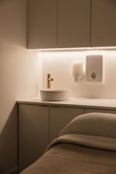 a white sink sitting on top of a counter next to a wall mounted toilet paper dispenser