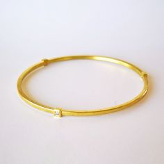 Solid 18k gold bangle with 3 bezel set diamonds. Hand forged bangle has a coarse matte finish with a silky sheen whereas the bezel settings are high polished for an interesting contrast and modern look. Mix and match several bangles for a layered and versatile look. Details: - solid 18k gold bangle, 2.0mm wide with an appr. thickness of 1.7mm  - 3 bezel set round diamonds .03ct each, vs quality, color G Can be ordered in 18k yellow or rose gold and in platinum (please add 2-3 weeks production time for platinum). Bangles are also available in shiny or antique finished sterling silver with your choice of 3, 6, 9 or 12 diamond settings in 18k gold. Different arrangements of the settings are possible. Sizing: Bangle sizes are measured by your hand and not your wrist size (as the bangle needs t Gold Bangle With Single Diamond For Gift, Gold Bangle With Single Diamond, Gold Diamond Bangle With Bezel Setting, Modern Gold Diamond Bracelet With Bezel Setting, Fine Jewelry Yellow Gold Bangle With Bezel Setting, Yellow Gold Bangle With Bezel Setting Fine Jewelry, Gold Cuff Bracelet With Single Diamond As Gift, Yellow Gold Bangle Diamond Bracelet With Bezel Setting, Yellow Gold Bangle With Bezel Setting