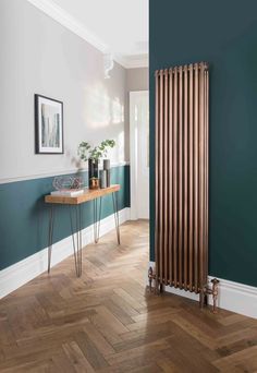 a room with blue walls and wooden flooring next to a large radiator