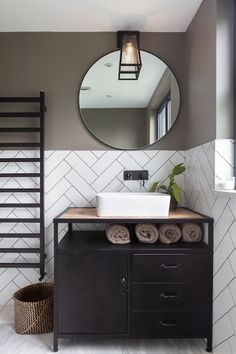 a bathroom with a sink, mirror and towel rack on the wall next to it