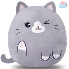 a gray cat stuffed animal sitting on top of a pillow