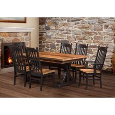 a dining room table with six chairs and a fire place in the fireplace behind it