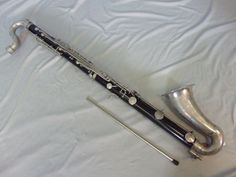 a silver and black flute laying on top of a white sheet