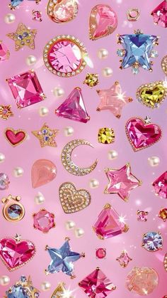 many different colored jewels and pearls on a pink background