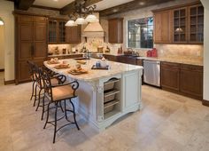 a large kitchen with an island in the middle and lots of cabinets on both sides