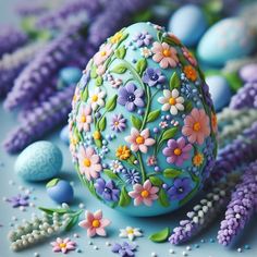 an easter egg with flowers painted on it surrounded by purple and blue eggs in the background