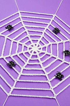 a spider web on a purple surface with black and white decorations in the center,