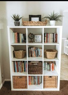 a white book shelf with baskets and books