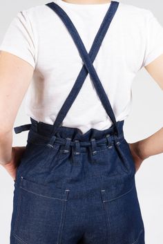 the back view of a woman wearing overalls with suspenders and a white t - shirt