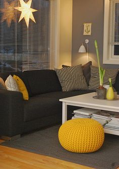 a living room filled with furniture and a yellow bean bag on top of a coffee table