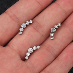 three diamond studs are shown in the palm of someone's hand