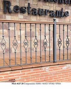 an iron fence with the words restaurante on it in front of a brick building